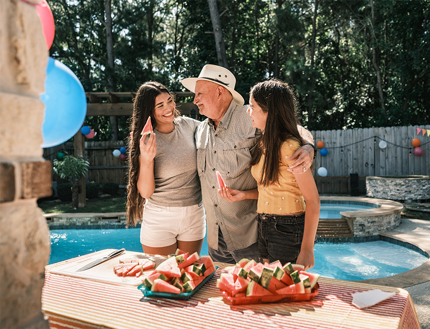 Grandfather and granddaughters by pool