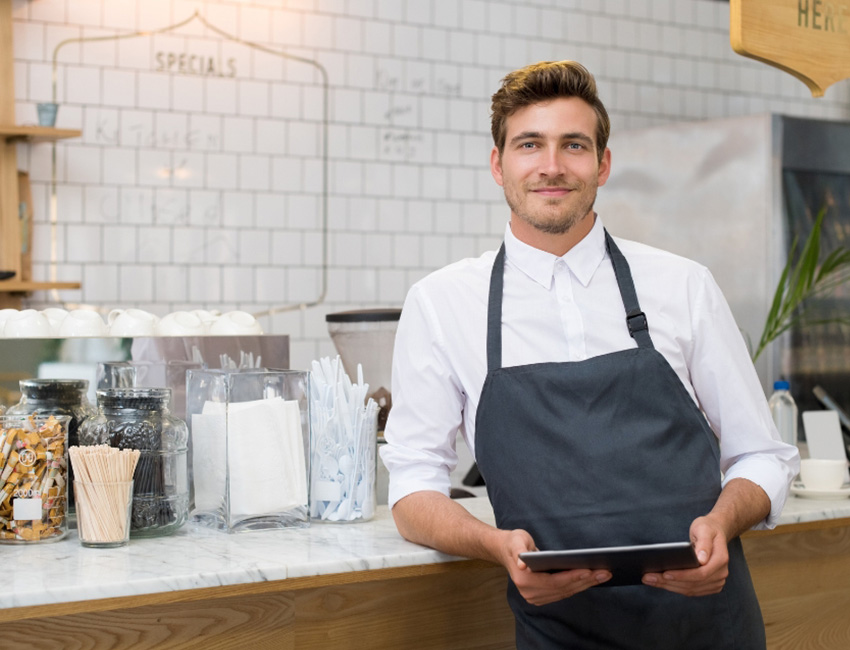 Man standing by counter holding ipad