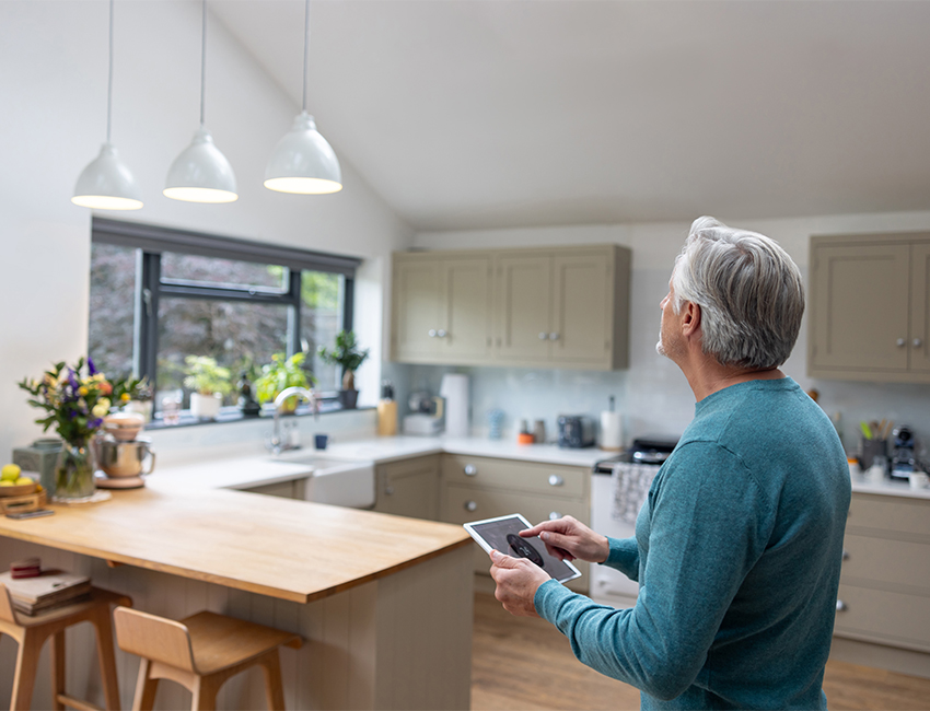 Man dimming lights in kitchen