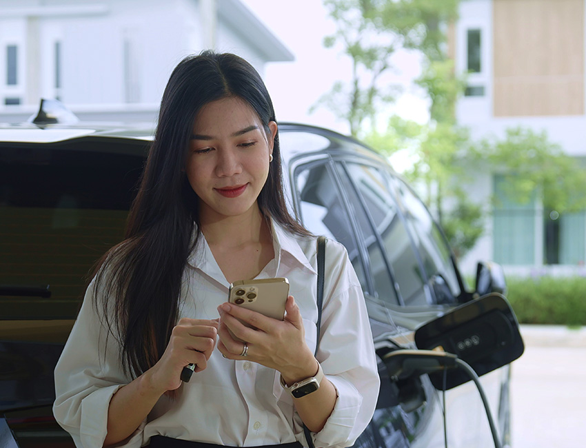Lady on phone charging car