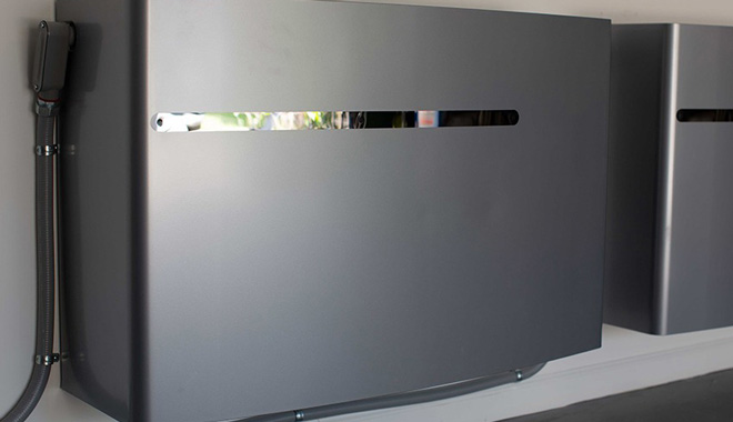 Wall-mounted home battery units with connected cables in a garage