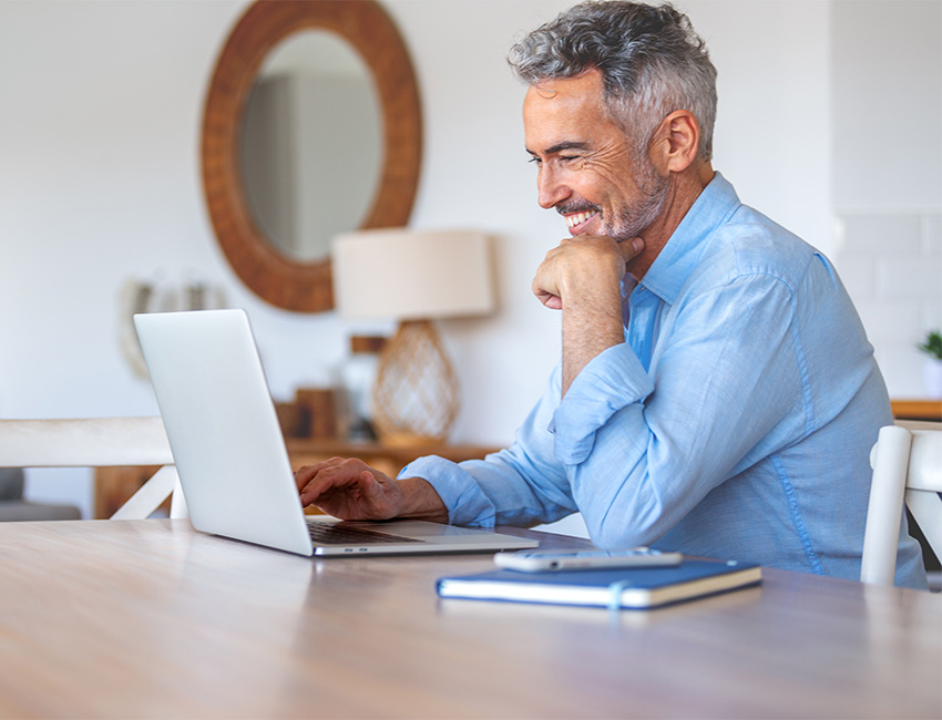 Man smiling at counter with laptop