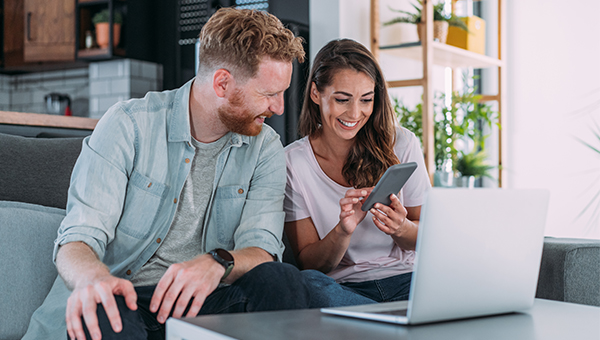 Couple browsing laptop and phone