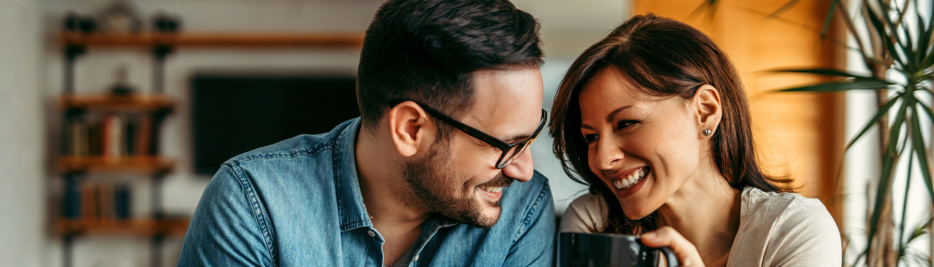 Happy couple smiling while drinking coffee