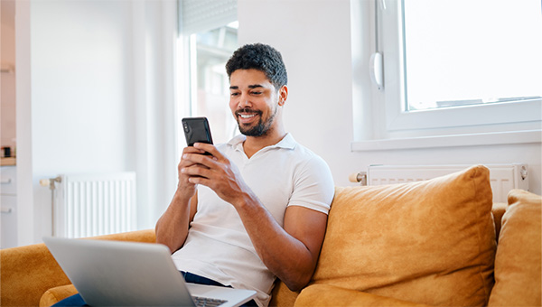 Man sitting on orange couch on phone