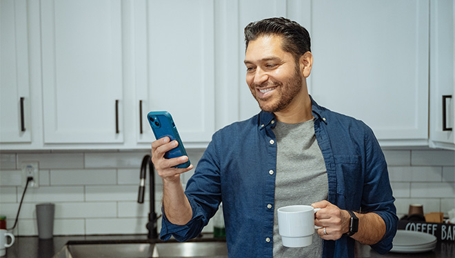 Man holding phone in kitchen