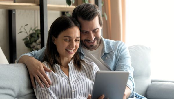 FAQ Couple on Couch Looking at iPad