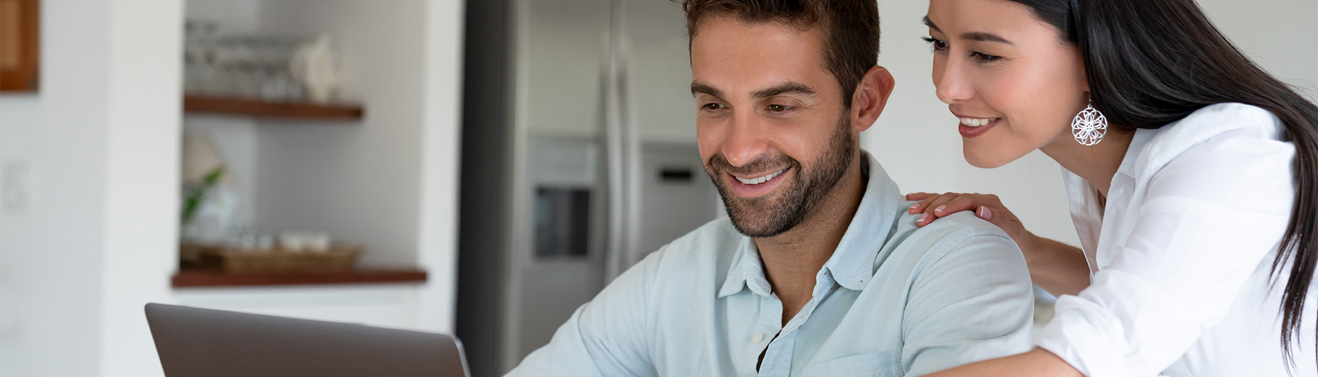 Couple smiling browsing laptop