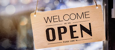 We Are Open sign hanging in a window