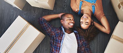 Couple lying next to boxes and smiling