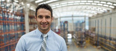 Happy manufacturing manager in warehouse
