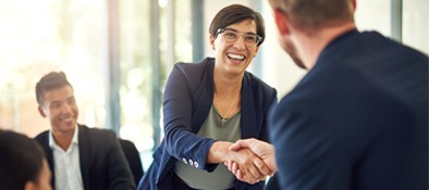 woman shaking man's hand in meeting