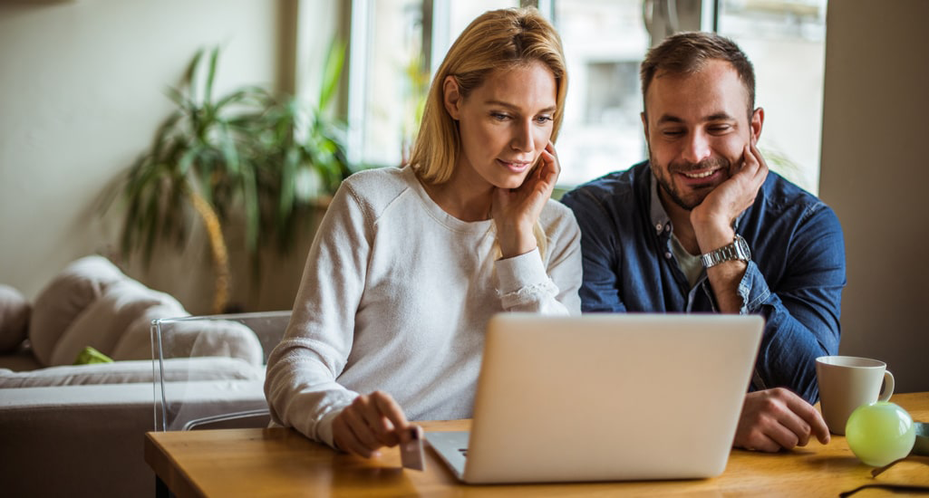 man and woman looking at computer screen